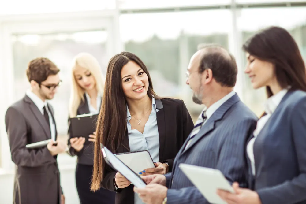 <p>Men and women with notepads and tablets in discussions.</p>